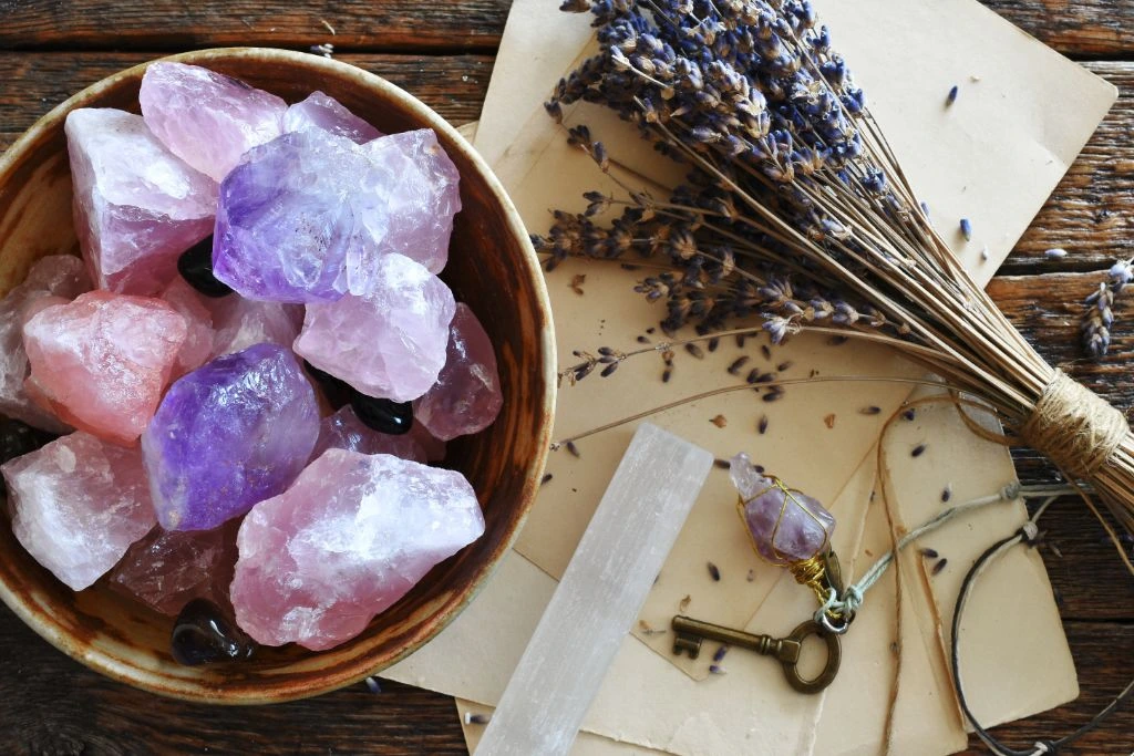 Rose Quartz and Amethyst in a bowl beside a selenite stick