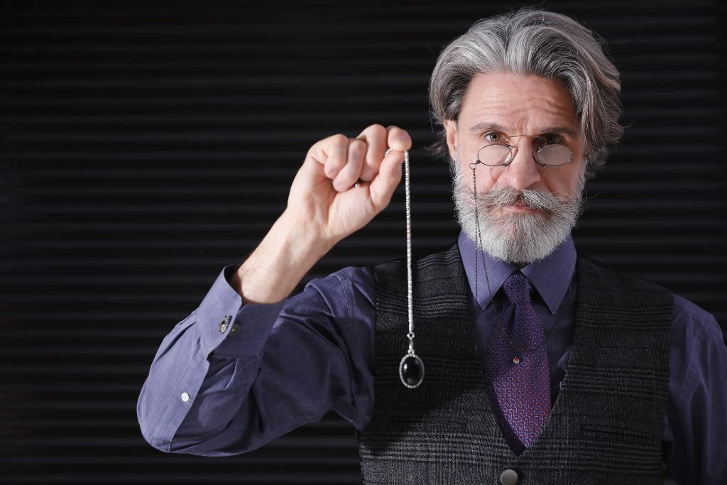 An old man holding a Black Tourmaline Pendulum