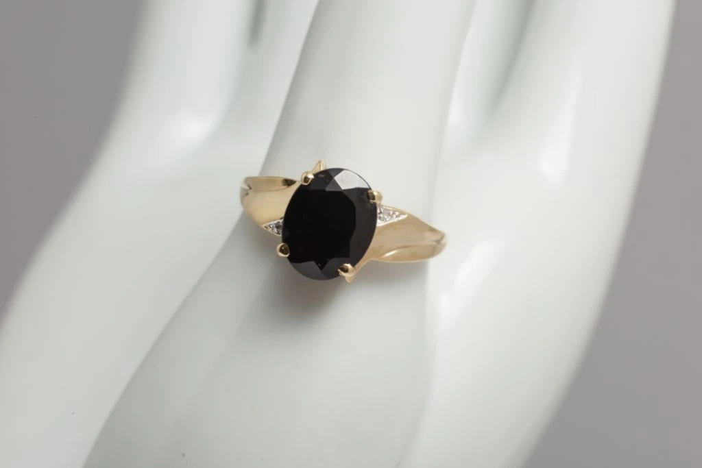 A mannequin hand is wearing an onyx ring