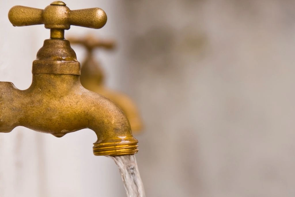 An open faucet flowing with water