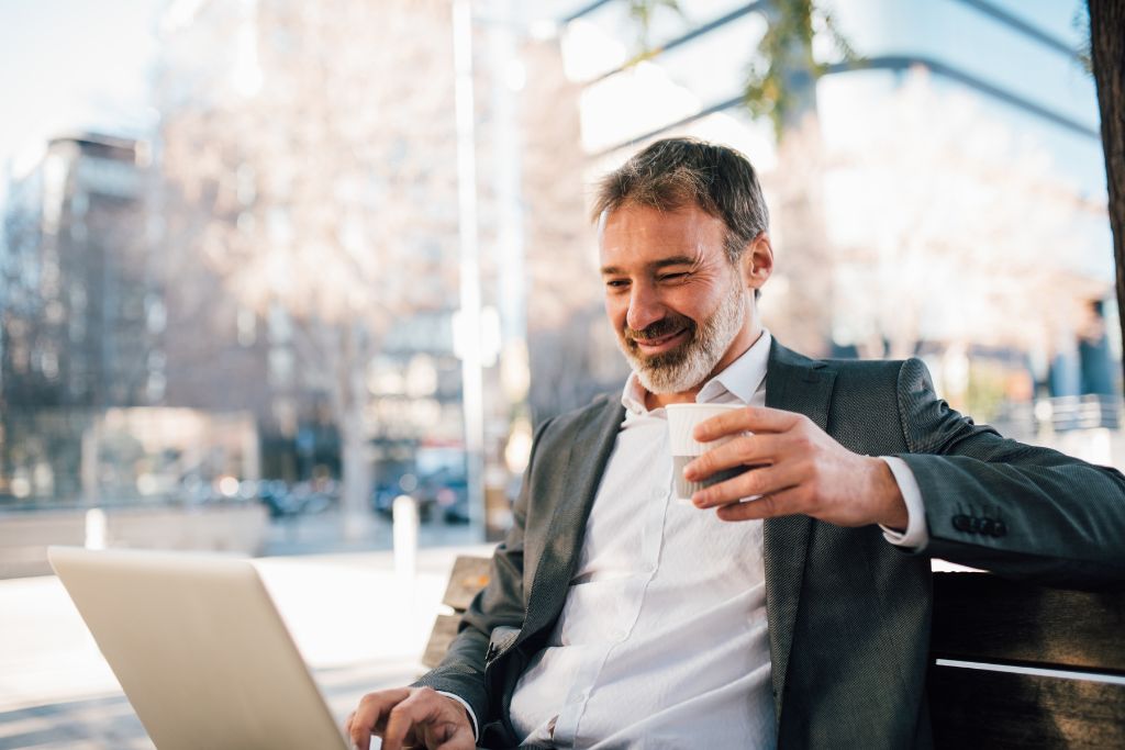 a happy man working on his laptop