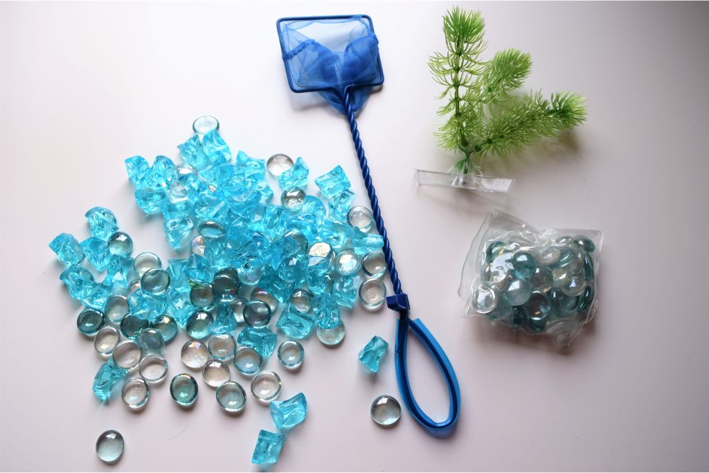 Crystals, fishing net and artificial plant on a grayish white bakground