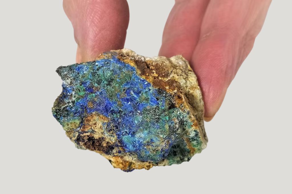 close up look of a hand holding a raw Linarite