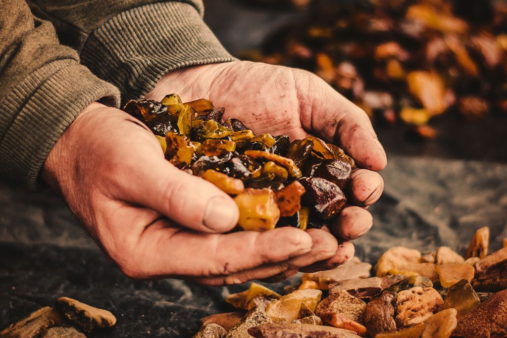 pressed amber chunks on male hands