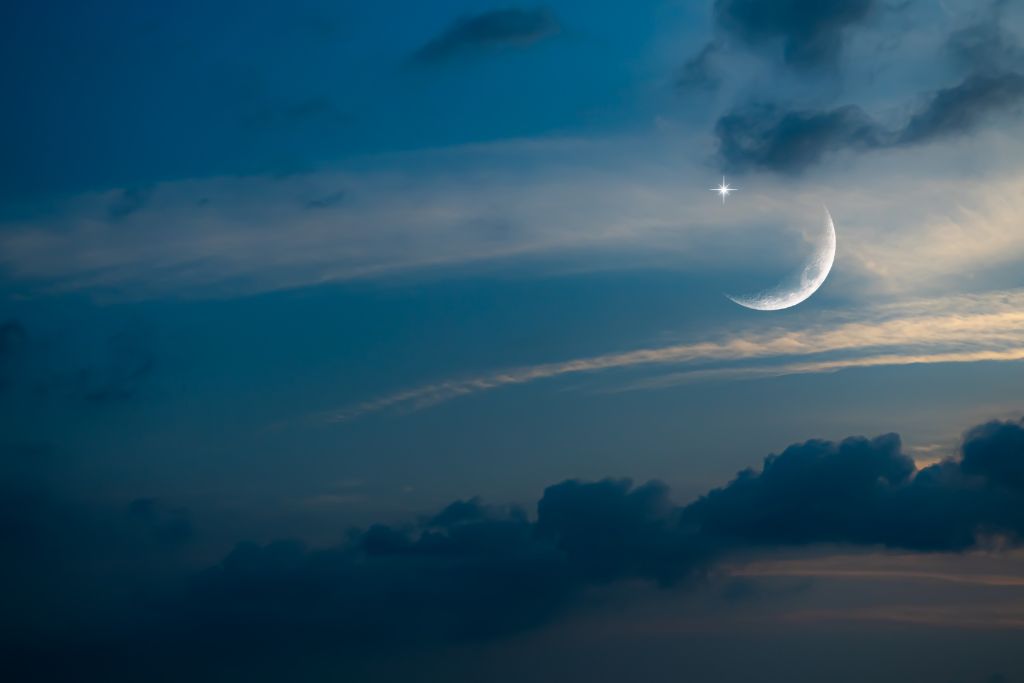 new moon in blue sky