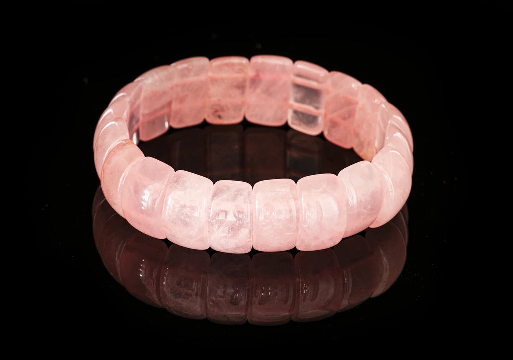 Rose Quartz bracelet on a reflective black background