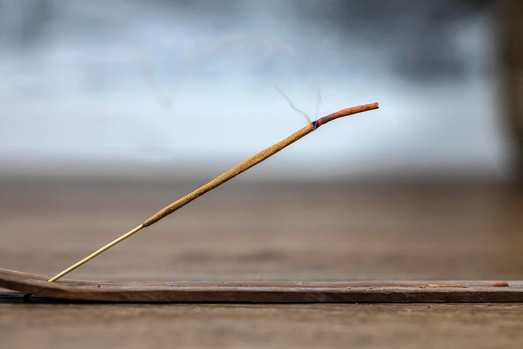 lit frankincense stick on a table