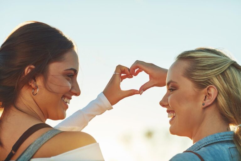 2 female model making a heart shape with their hands