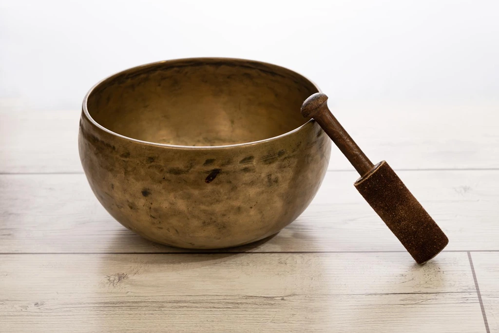 handmade tibetan singing bowl placed on wooden table