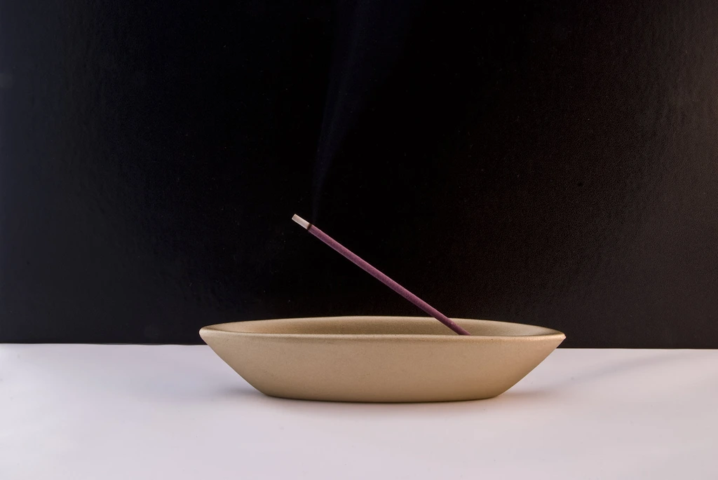 incense stick in a clay bowl