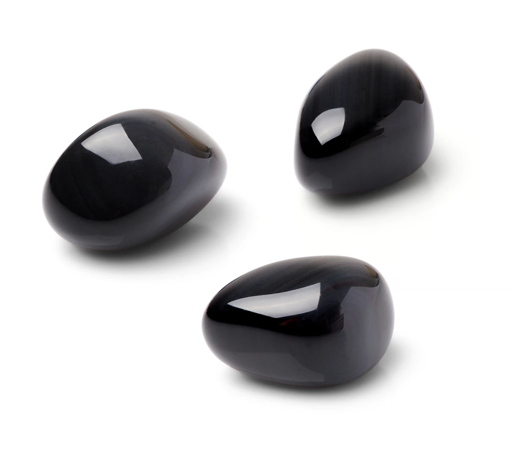 3 pieces of polished and shiny black obsidian crystals on a white background