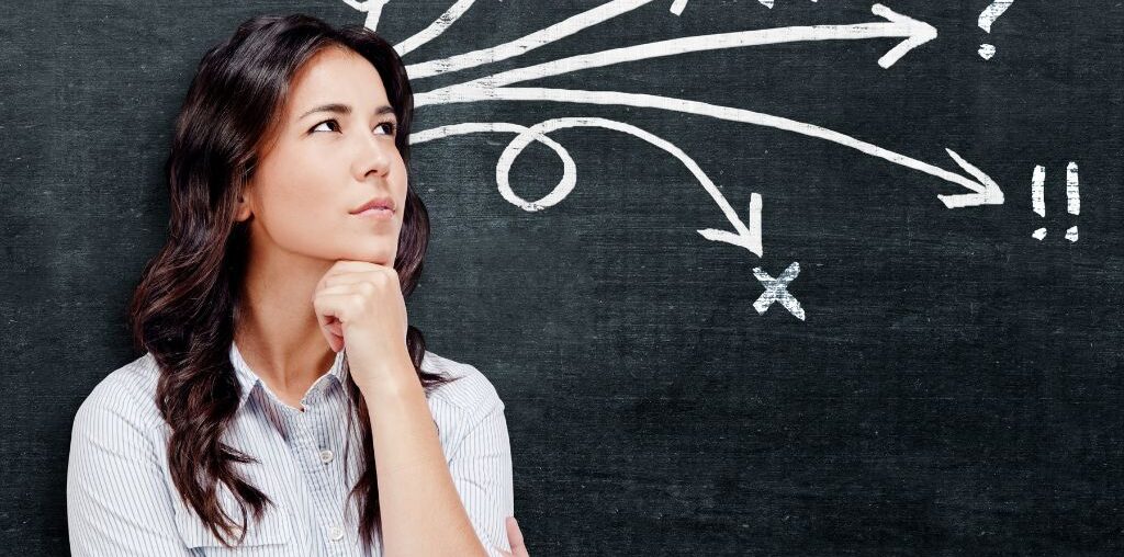 woman thinking in front of a blackboard