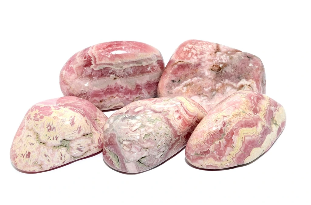 5 pieces of polished rhodochrosite on a white background