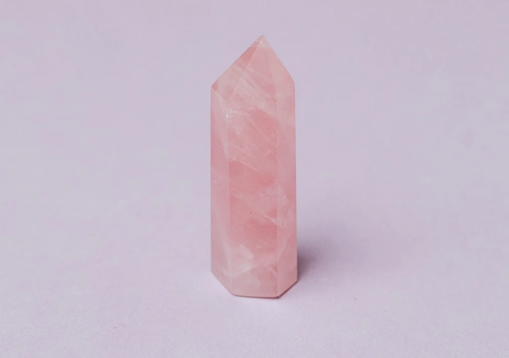 Rose Quartz wand on a pinkish background