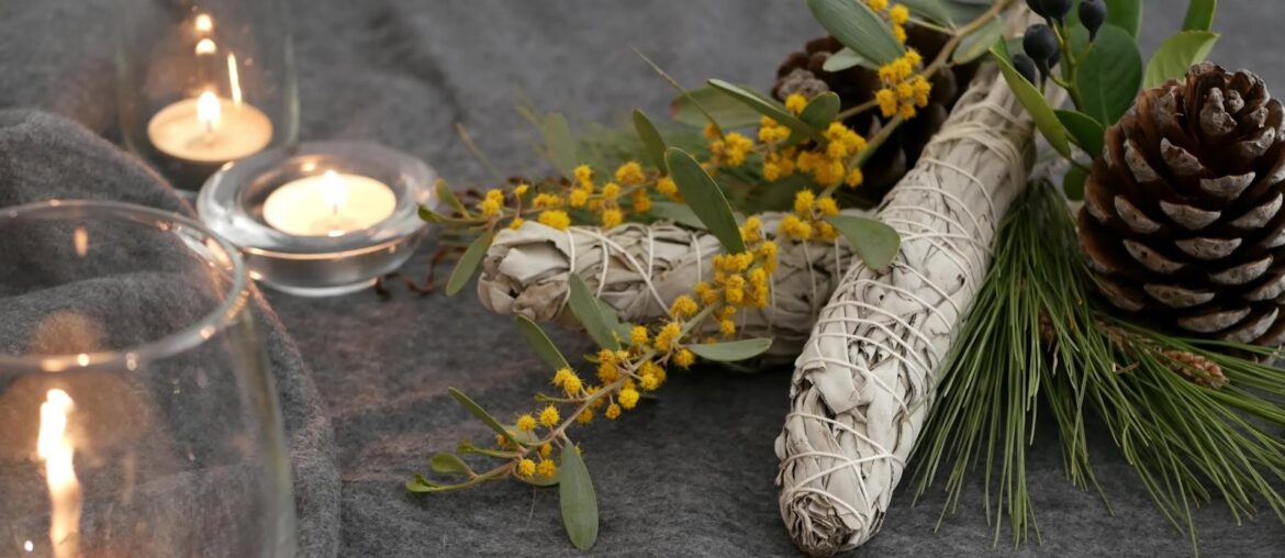 sage smudge sticks with dried flowers and candles on a wood table