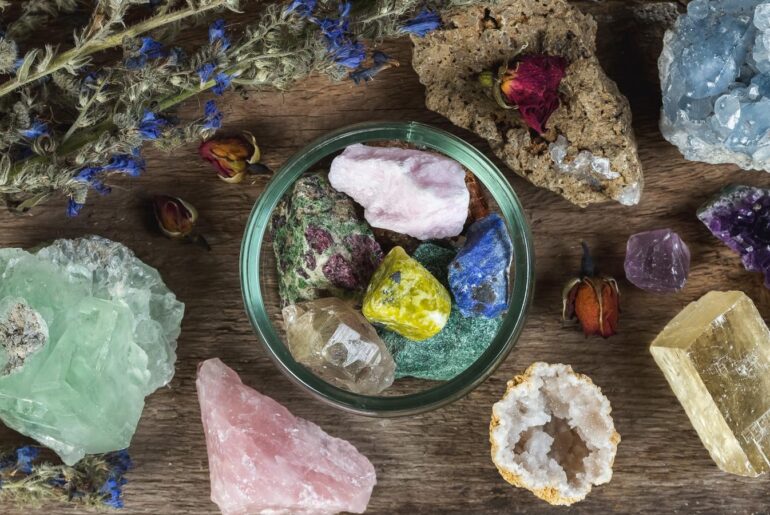 assorted crystals in a bowl and on a wooden table
