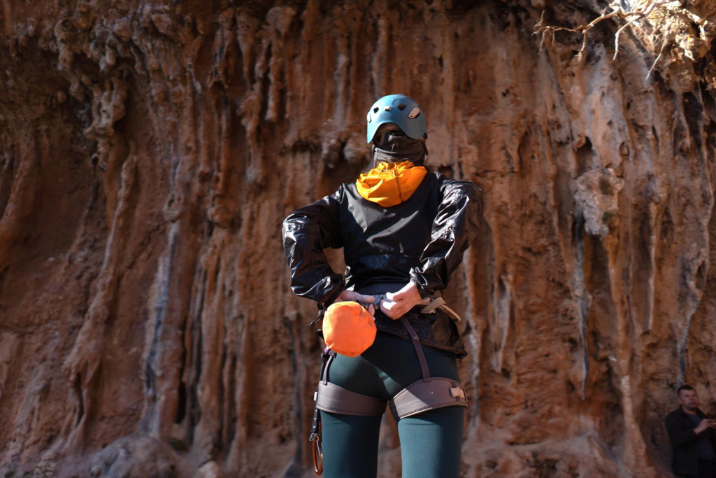 a woman in front of rock formation she is looking to climb