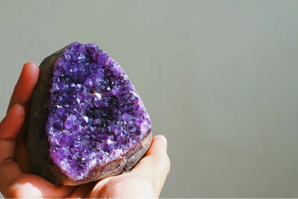 Amethyst Crystal with Sunlight Exposure on a grey plain background