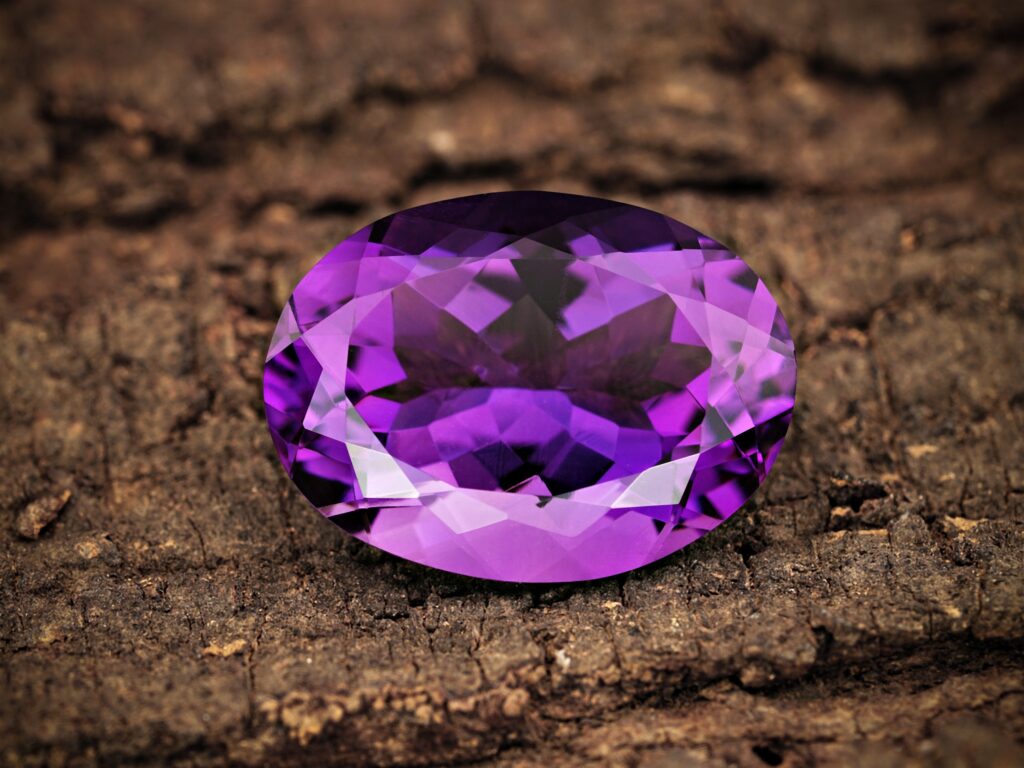 amethyst crystal gem on top of wood
