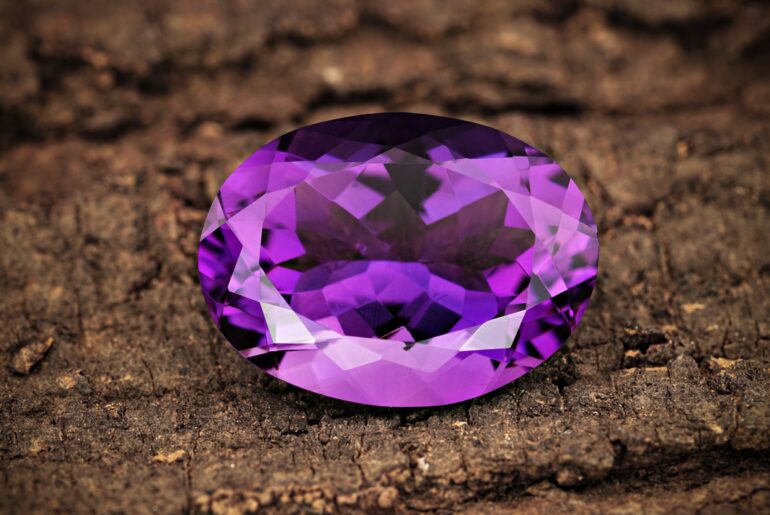 amethyst crystal gem on top of wood