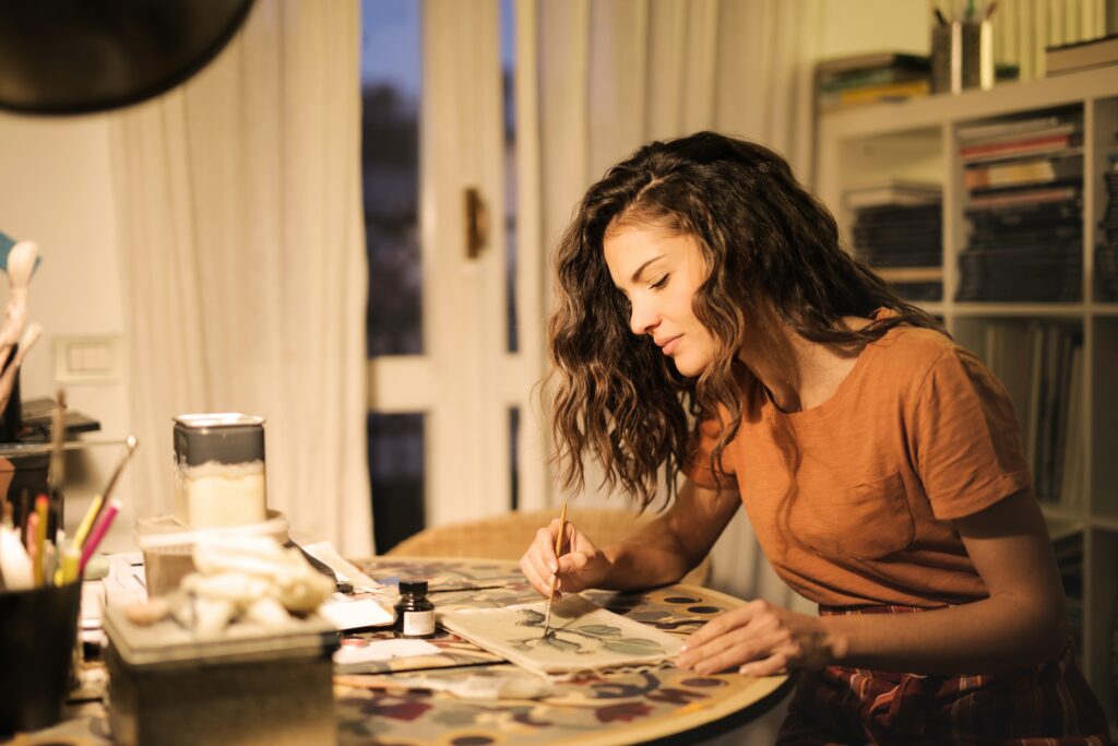 a woman painting leaves