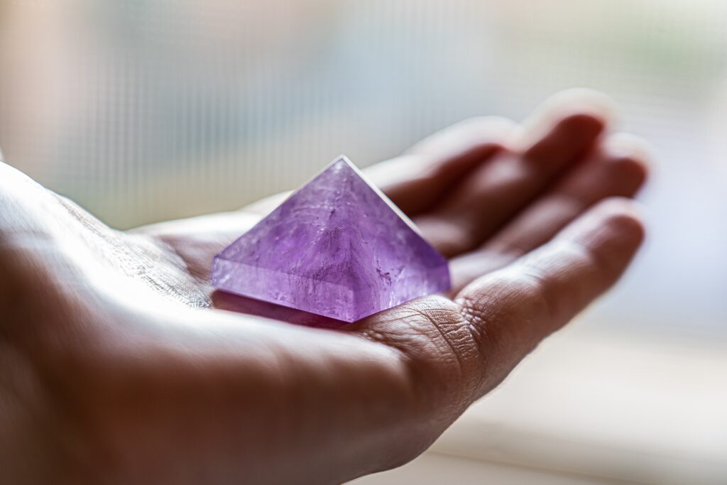 amethyst pyramid on an open palm