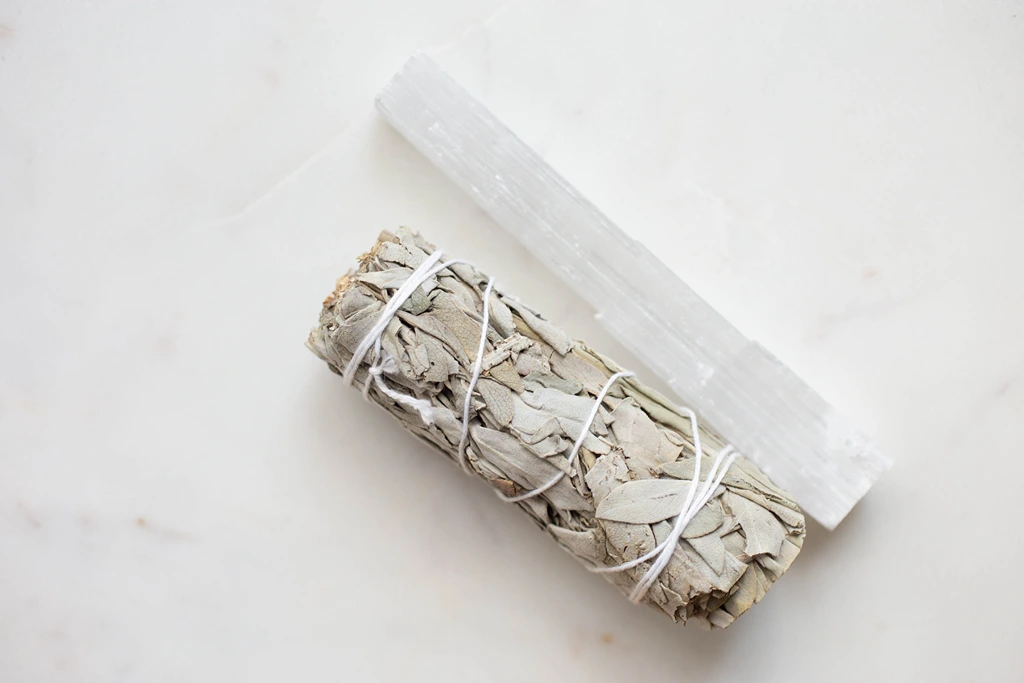 sage smudge stick with selenite tower on white background
