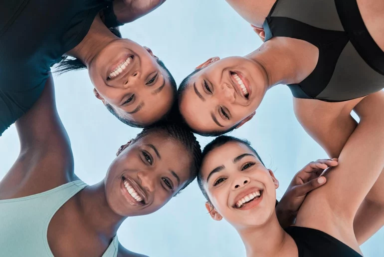 four female friends with arms around each other