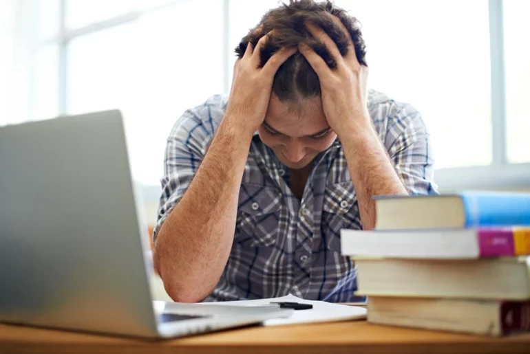 man holding his head with both hands a sign of stress