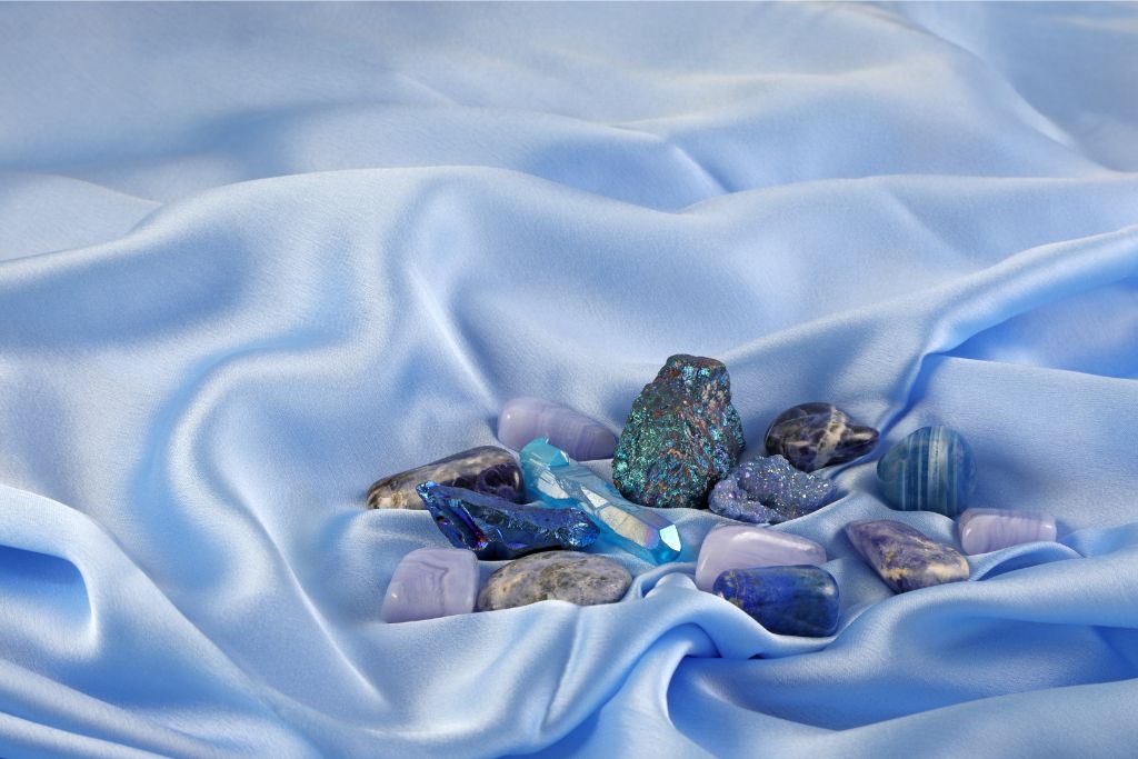 blue throat chakra crystals on a blue silk cloth