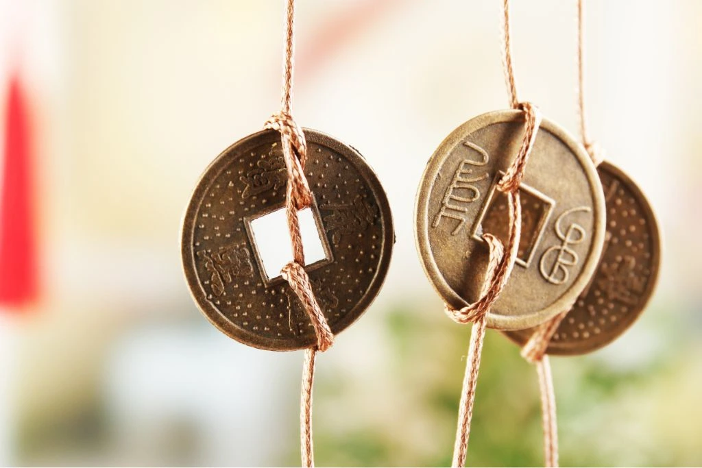 coins for feng shui hanging on a red string
