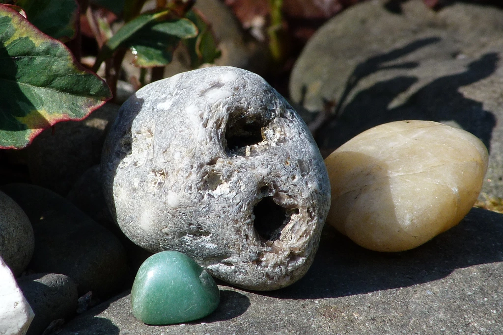 Hag stone with different crystals on a garden