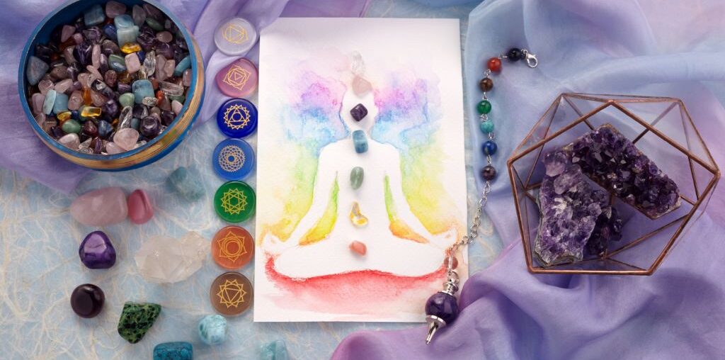 crystals, crystal pendulum and chakra painting flatlay