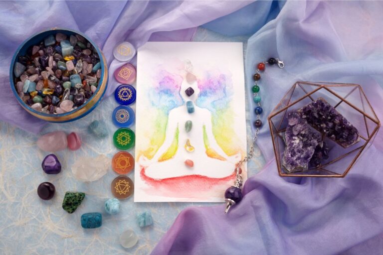 crystals, crystal pendulum and chakra painting flatlay