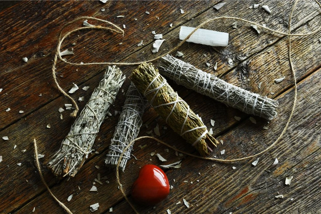 smudge sticks with rope and crystals on a wooden table