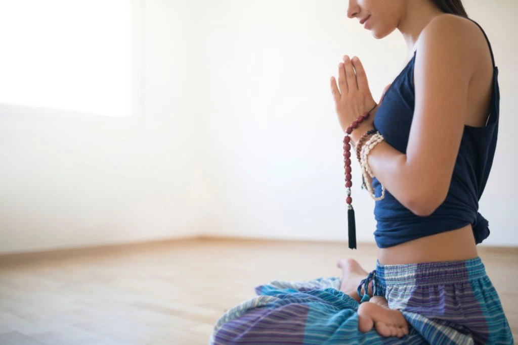 woman reciting mantras in an empty room