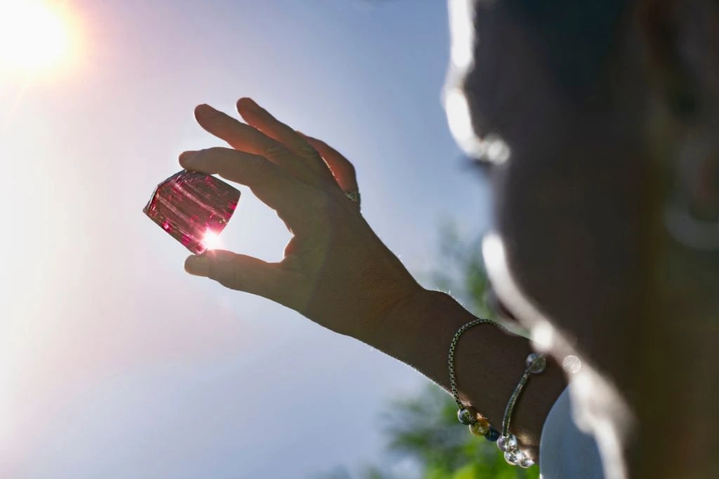 woman bathing her crystal on direct sunlight