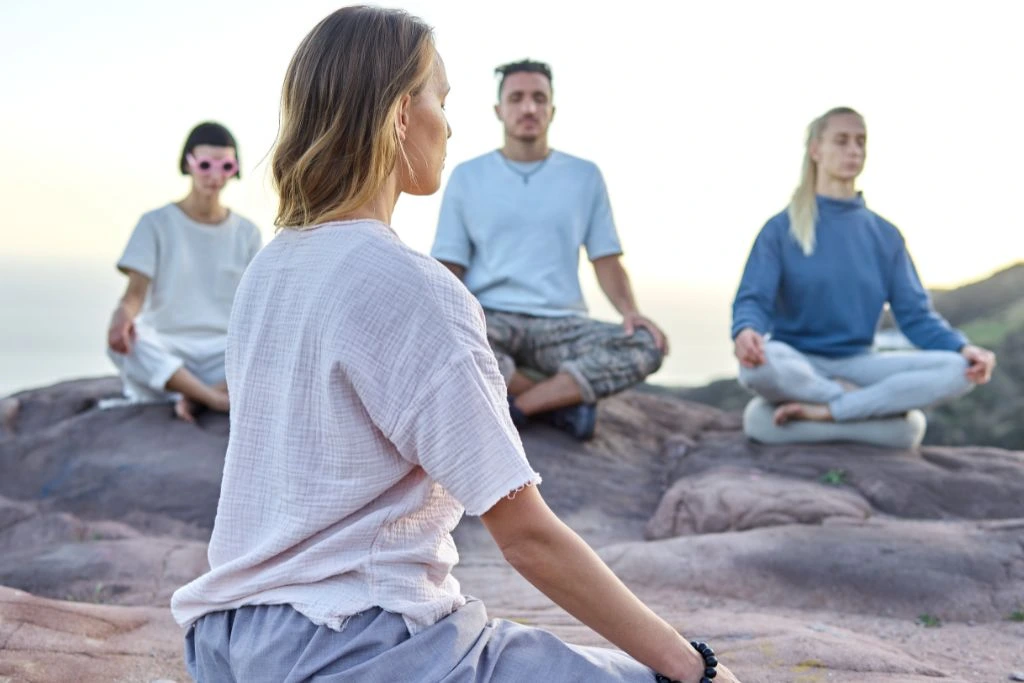 group of people meditating outdoors