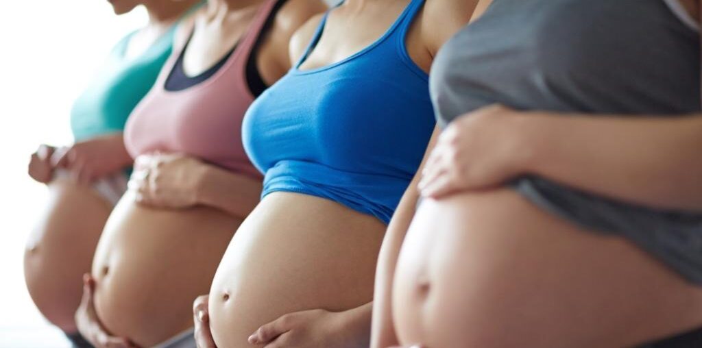four pregnant women in line