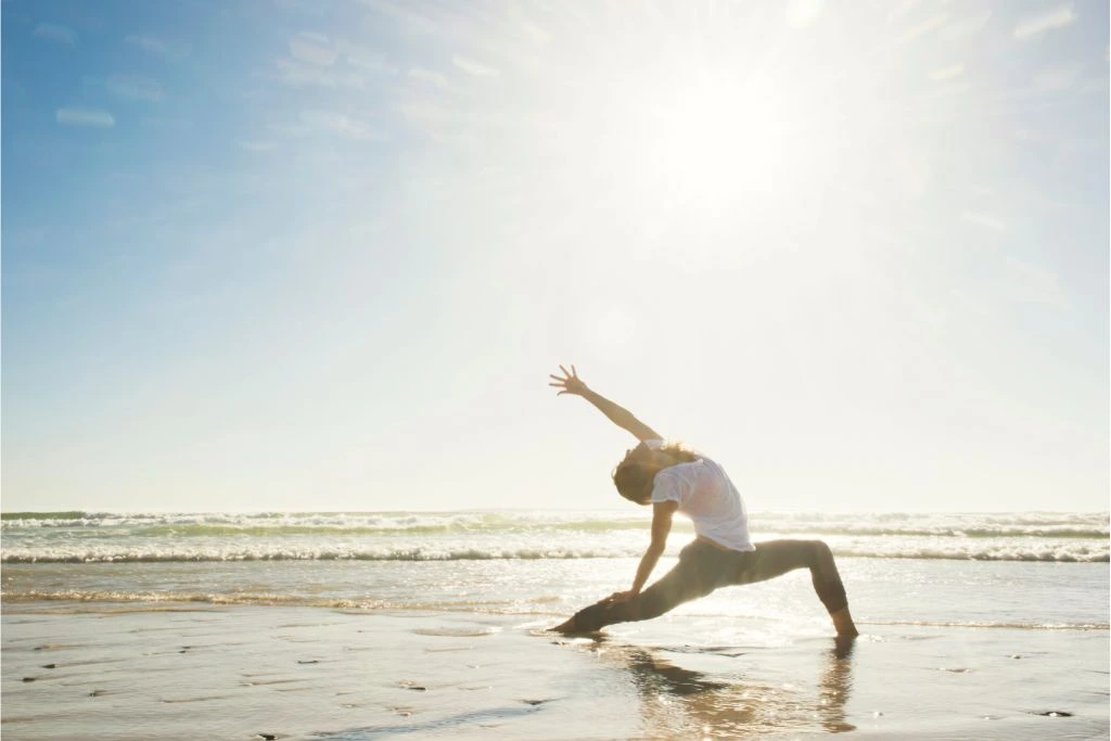 woman doing yoga at the beach