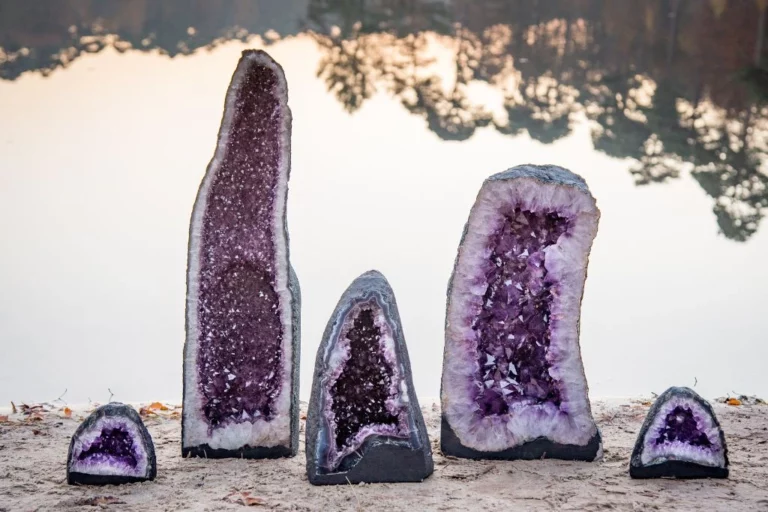 big and small amethyst geodes on a stone ledge