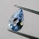 Aquamarine crystal placed on tip of a scissors