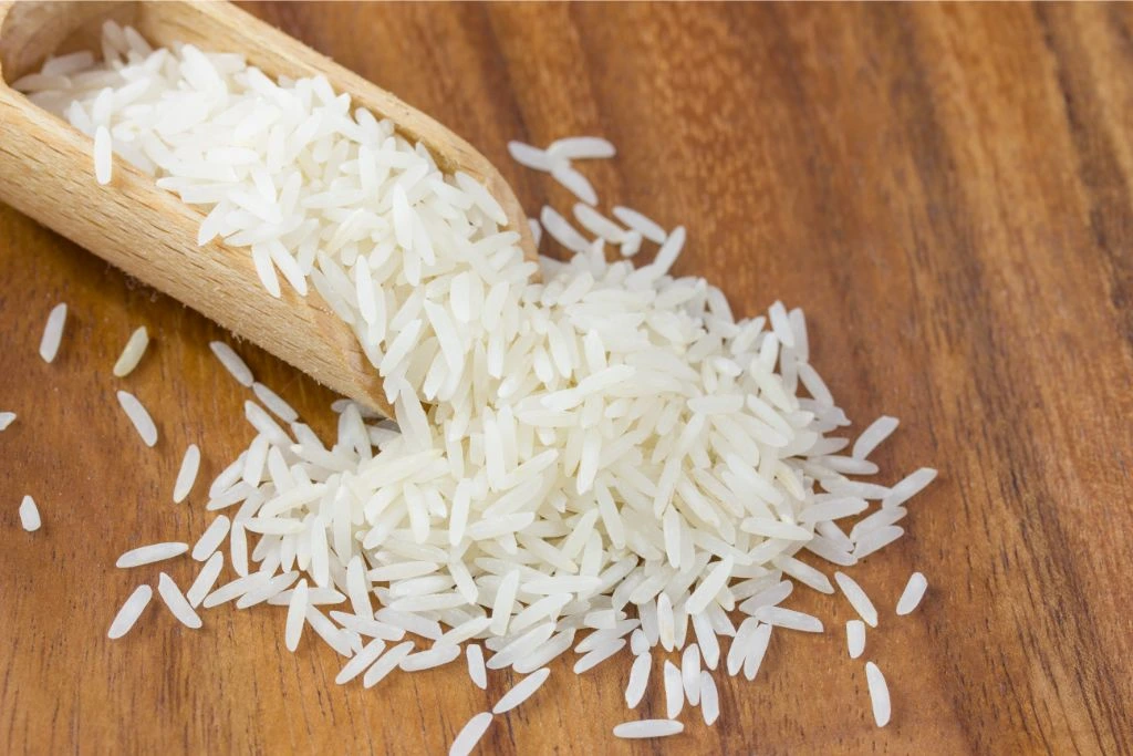 rice spiling out of a wooden scooper