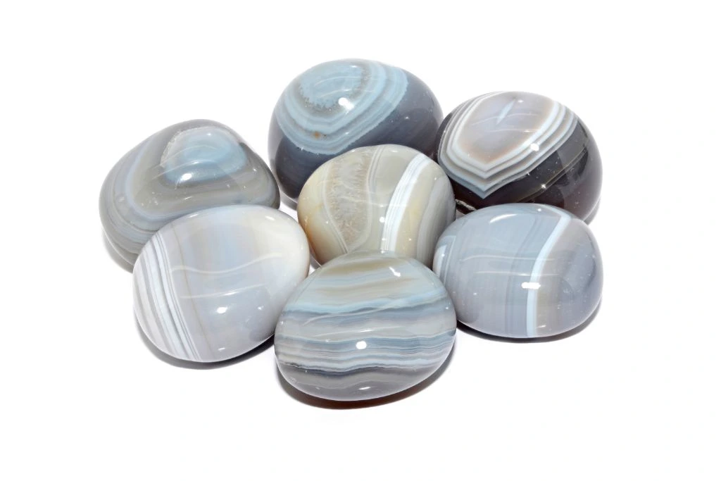 polished botswana agate stones on a white background