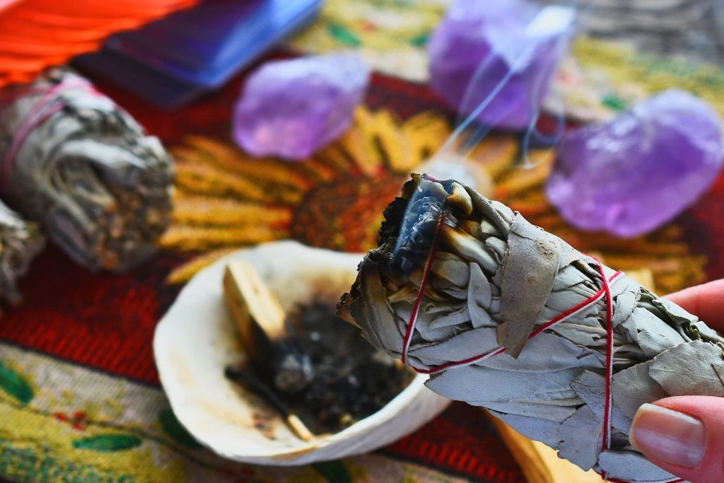 Cleansing sage smudge stick with 3 Amethyst crystals on the background