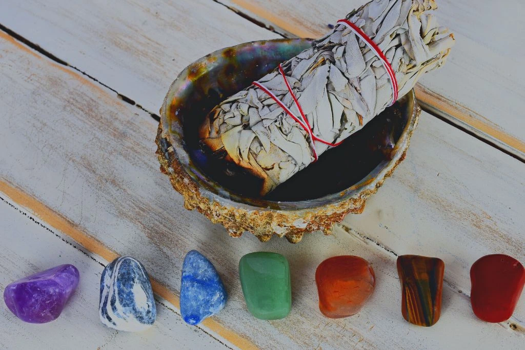 Cleansing 7 chakra crystals placed on a wood surface with an Abalone Shell