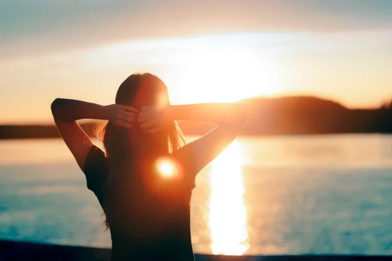 woman standing at the beach during sunset