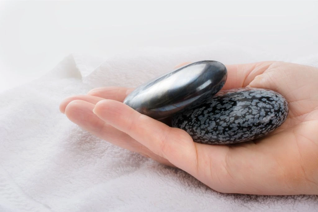 hematite and Snowflake Obsidian in a model's hand