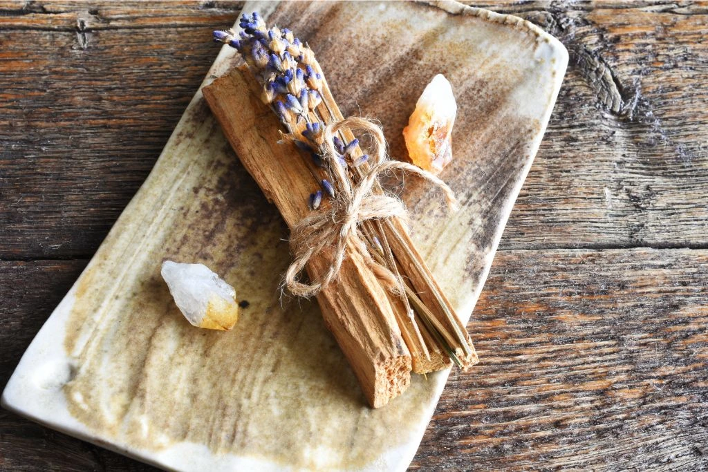 quartz and smudge sticks on a wooden board
