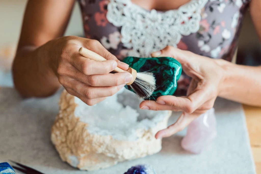 woman dusting malachite crytals